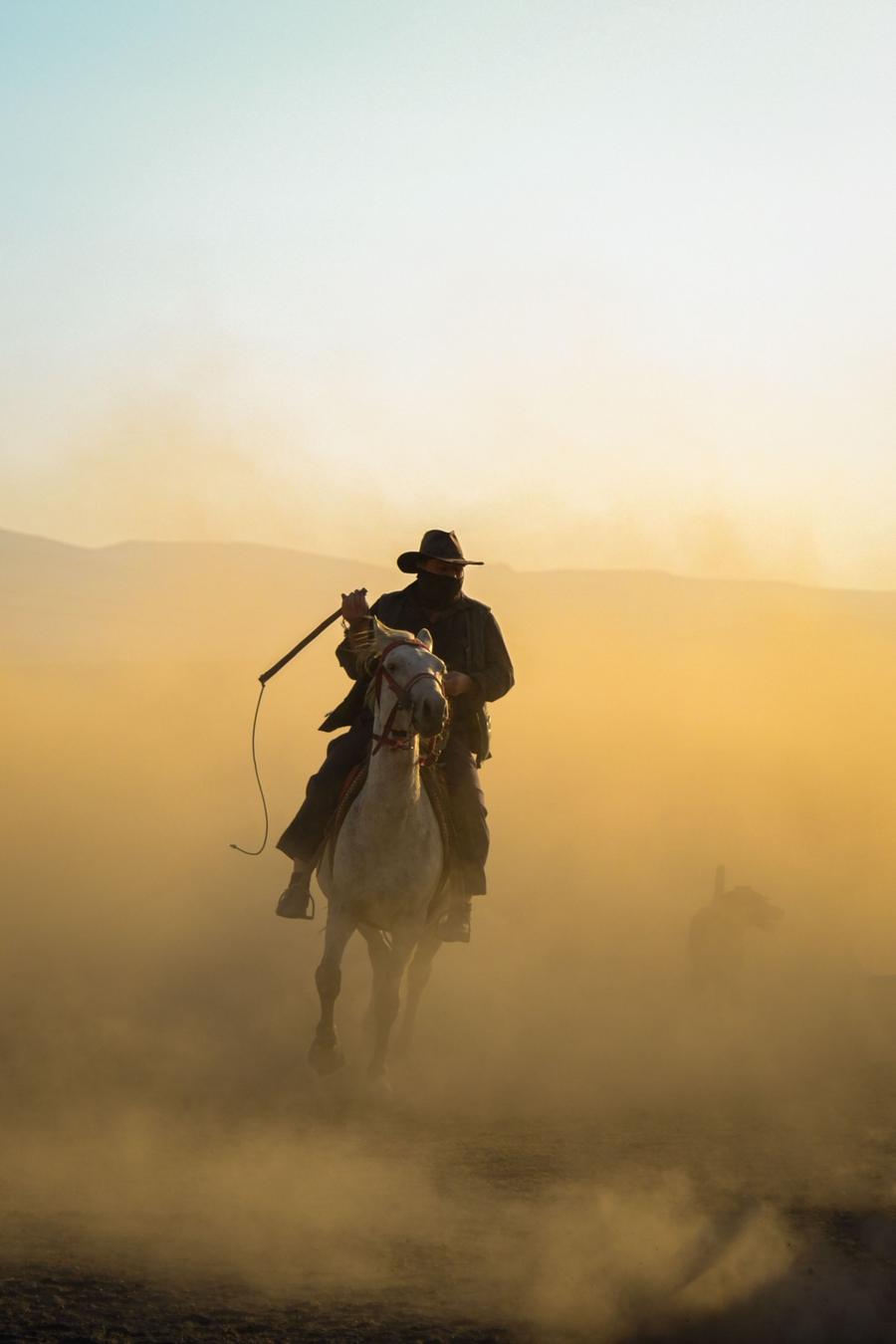 A rider on a horse along a dusty trail near Calgary, Alberta